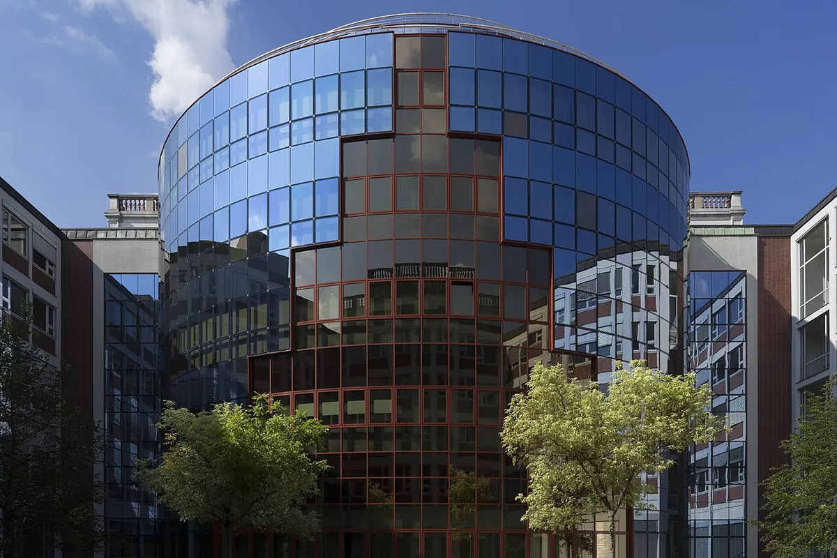 The inner courtyard of the Börse today, with trees, modern wings and a curved glass wall on the site of the burned-out hall