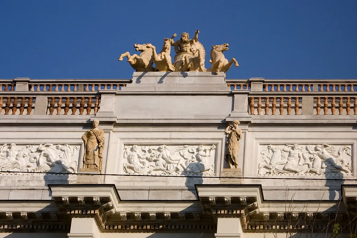 The roofline of the old Börse, with a sculpted frieze, statues between the panels and a gilded group of horses and a chariot above the balustrade