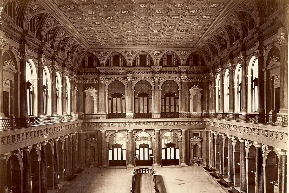 A photograph of the great trading hall of the Börse about 1880, with two storeys of columns and arches, a coffered ceiling and a marble floor